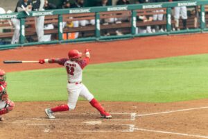 Rafael Devers at bat in a Boston Red Sox uniform, swinging powerfully.